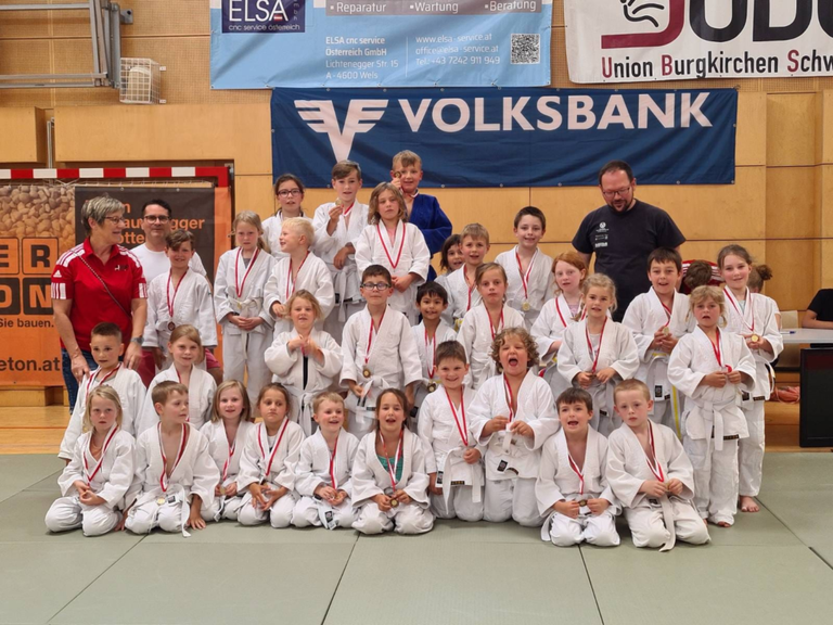 Judokids machen erste Schritte auf der Wettkampfmatte mit Unterstützung von Eltern und Geschwistern. Einige werden Juniorjuniorkampfrichter.